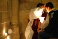 Un confesseur avec une étole violette donne l'absolution en marquant le front du pénitent d'un signe de croix.